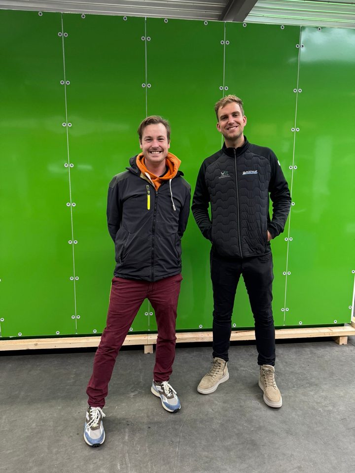 Bas de Bekker en Sjors Wagenaar voor een groene X-Cross-kast in de werkplaats
